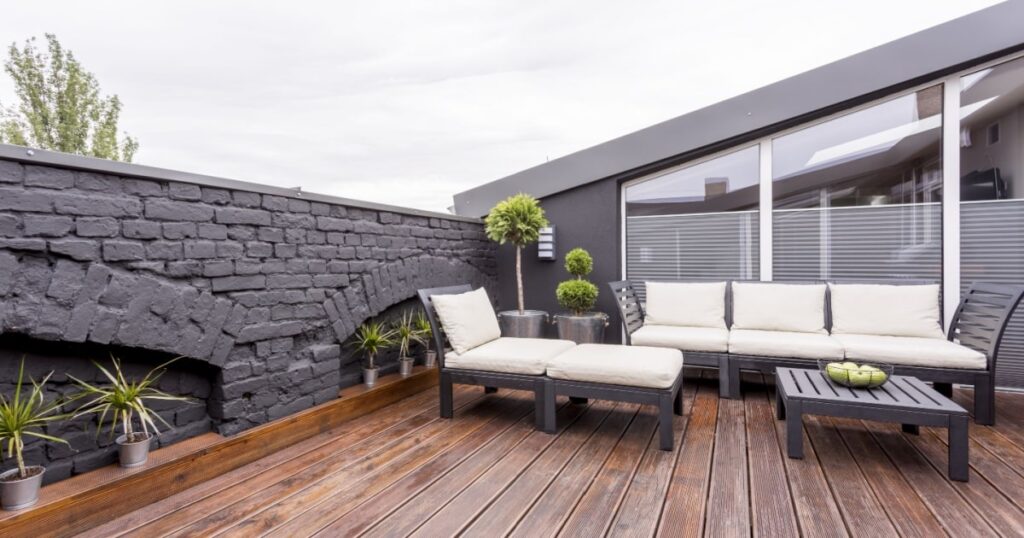 Une toiture terrasse aménagée en salon de jardin avec un revêtement en bois. 