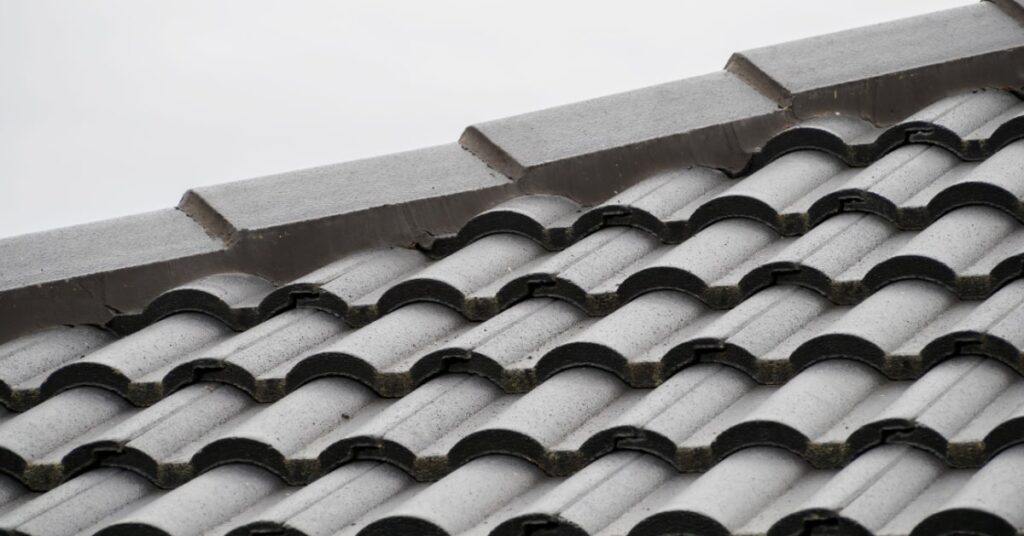 tuiles en béton grises placées sur une toiture en pente