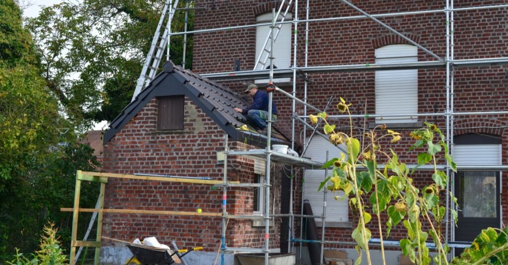 toiture en pente d'une extension de maison en train d'être réparé par un ouvrier après un problème d'infiltration