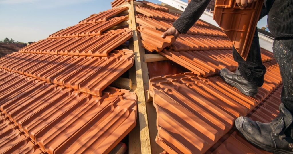 Zoom sur l'installation de tuiles en céramique sur une toiture de maison 